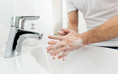Mann der sich die Hände wäscht an einem Waschbecken