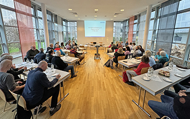 Informationsveranstaltung mit vielen Menschen auf Stühlen