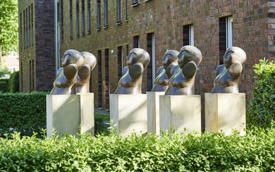 Ein Bild von Bronzenbüsten auf Steinsäulen